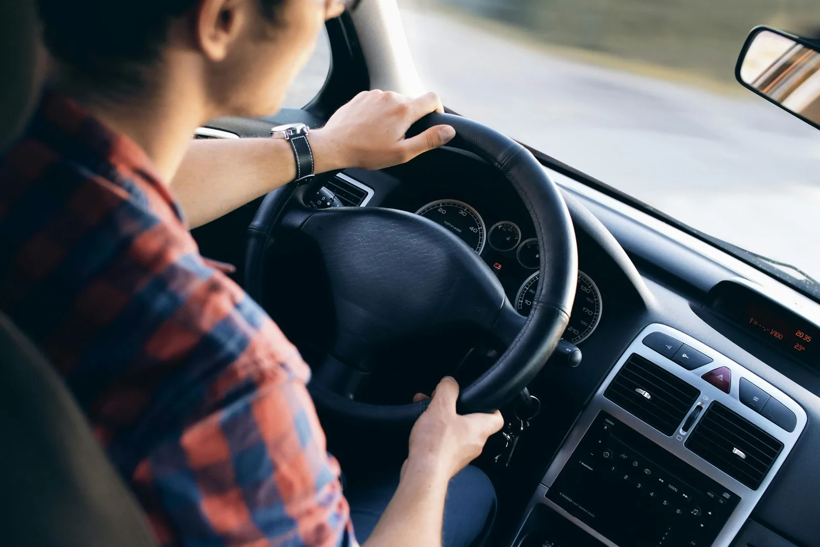 Driver with both hands on the steering wheel.
